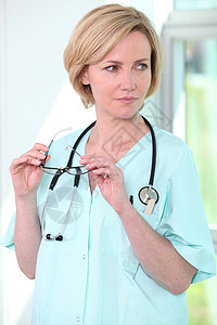 持有眼镜的护士诊所工作头发医院金发手术助手白色外科工人背景图片