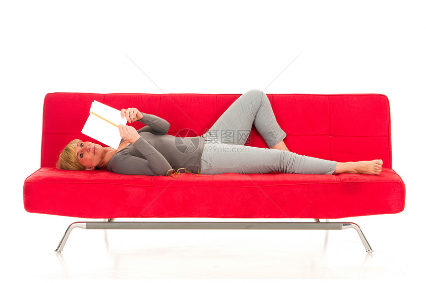 女人躺在沙发上看书成人说谎房子红色女性赤脚家具女士阅读休闲装图片