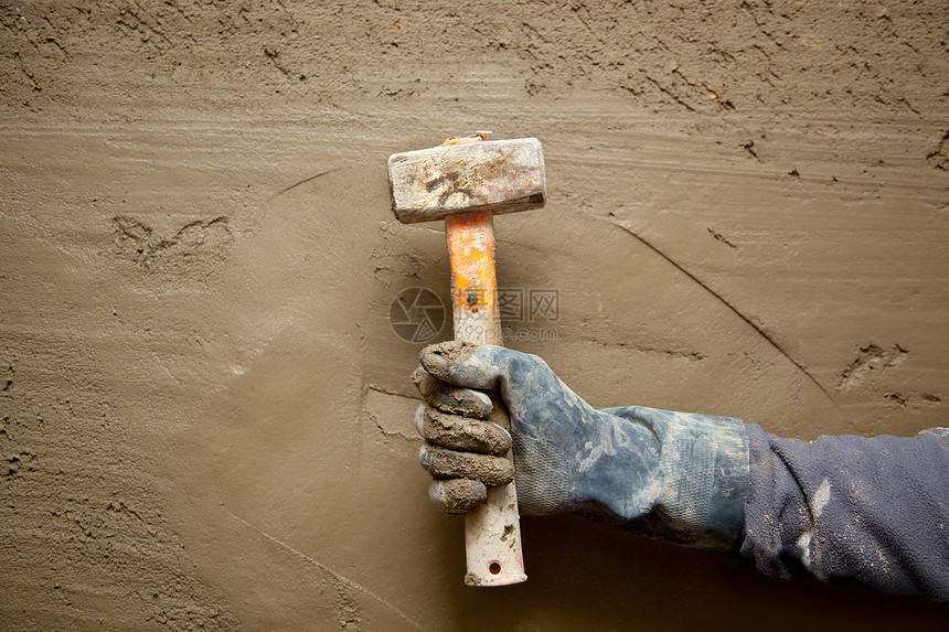 带手套的铁锤人 在石水泥背景下衰变工作砂浆男人手工劳动建筑拼装维修房子图片