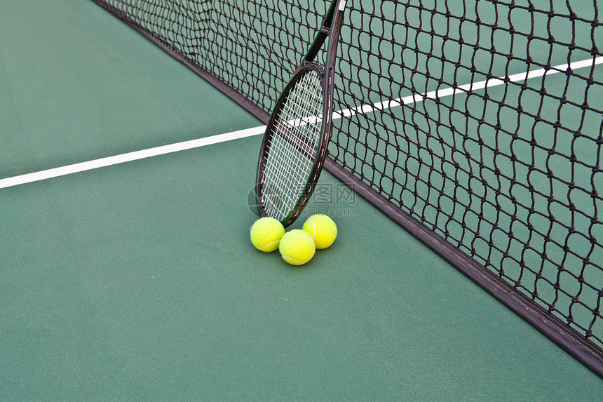 有球拍和球的网球场图片