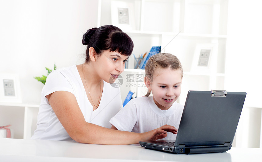 妈妈和女儿一起为笔记本电脑工作互联网房子办公室房间乐趣女士女性父母技术孩子图片
