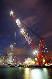 香港港的升帆船橙子加载码头船厂船运货物起重机日落造船港口背景