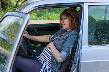 孕妇在车里对肚子说说话车轮腰带驾驶女性女士运输司机妈妈安全母亲优雅高清图片素材