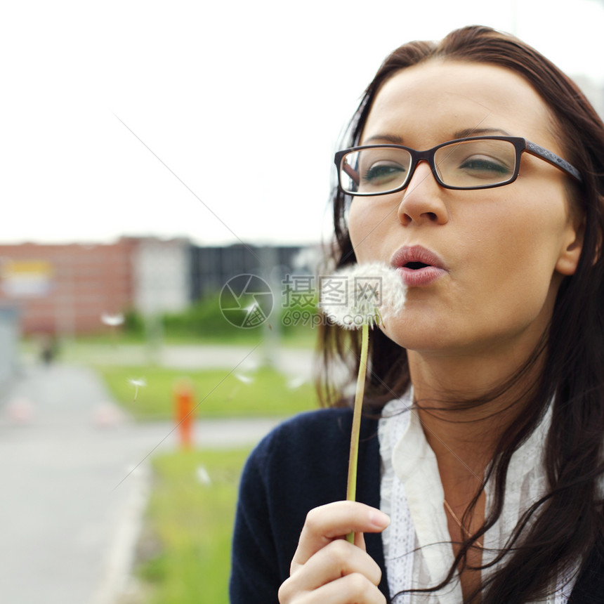 女孩吹在花朵上前景棕色快乐女性头发眼镜商务人脸会议生意图片