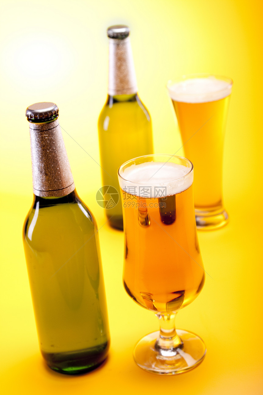 黄色背景的冷冻啤酒液体冷藏瓶子饮料茶点气泡派对玻璃酒吧棕色图片