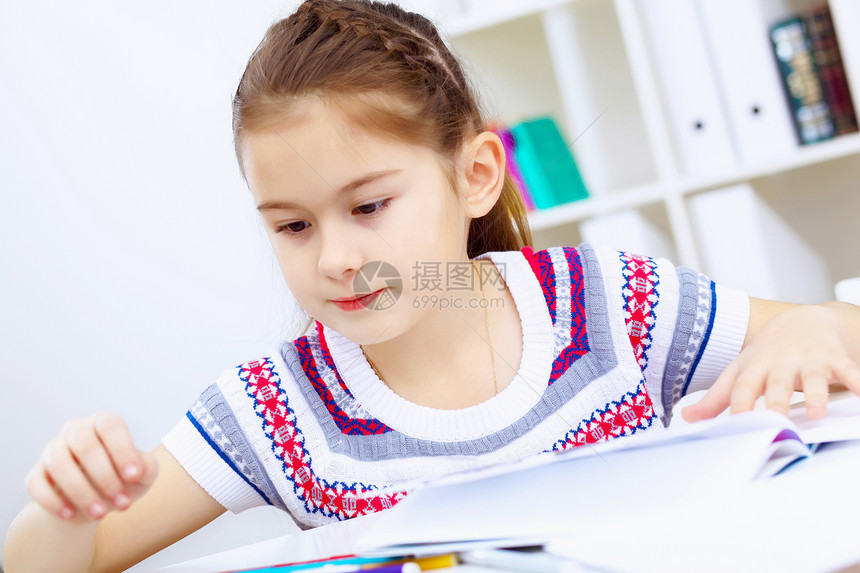 女孩和学习教科书桌子家庭作业童年女学生学校孩子微笑教育幼儿园图片