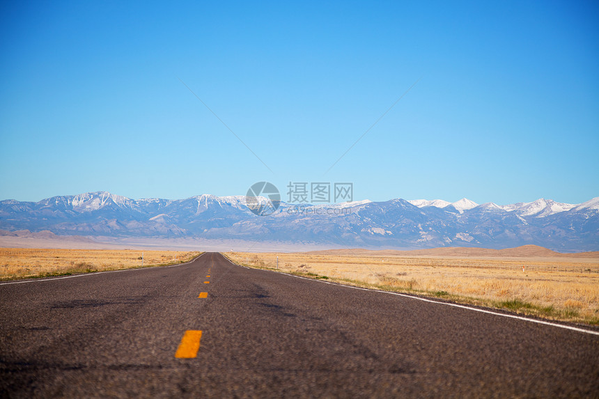 空高速公路驶近山地山脉沙漠自由蓝色天空场景孤独沥青车道城市地平线图片