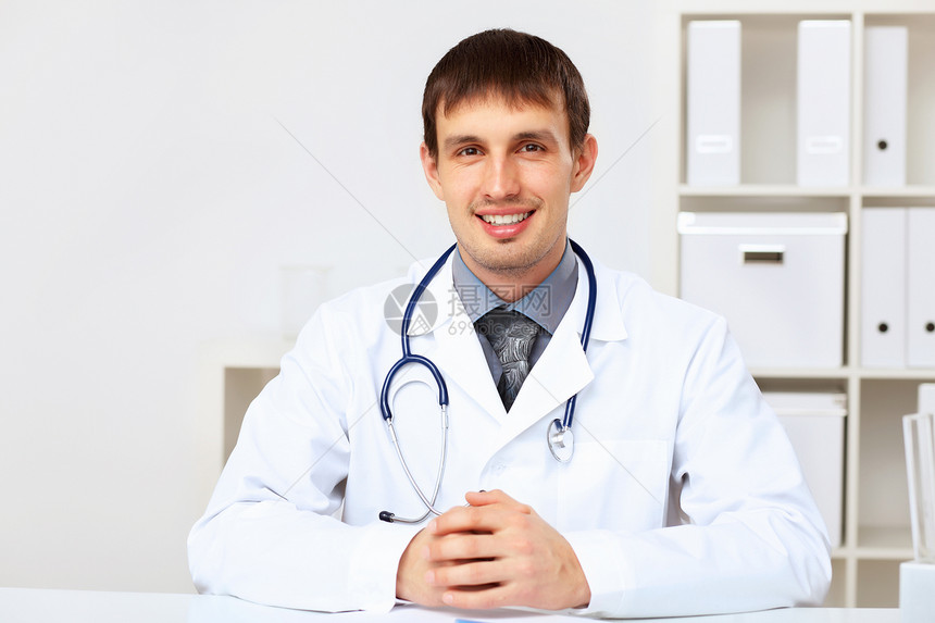 穿白制服的年轻男医生外科从业者蓝色诊所病人外套工作微笑医师工人图片