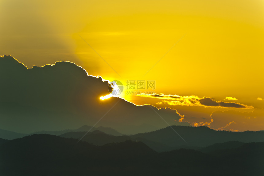 日落在山后面太阳地形光线顶峰水平黄色场景天空风景背光图片