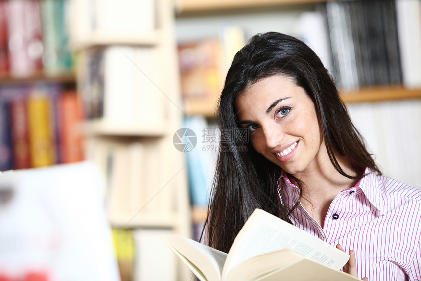 手拿书在书店微笑的女学生  模特青少年科学女性大学学生店铺教育书柜学习女孩图片