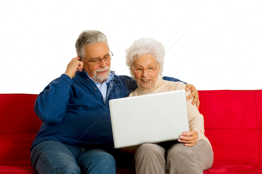 在沙发上用笔记本电脑的老夫妇按摩男人互联网牛仔裤成年人家庭生活眼镜技术工具夫妻图片