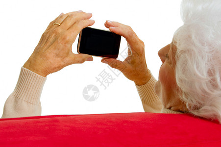 拥有智能电话的老年妇女通讯家庭生活技术白色红色工具沙发手机触摸屏背景图片