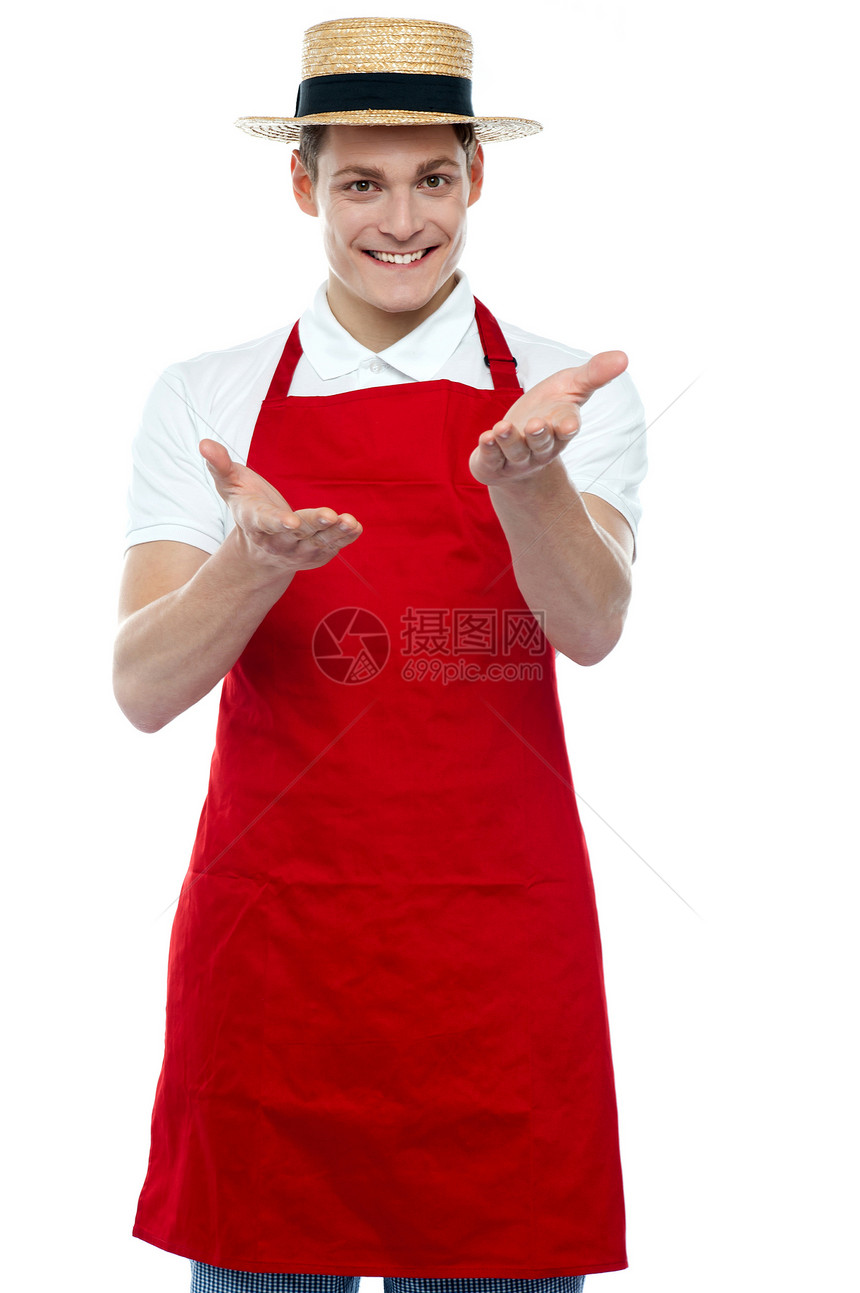 英俊的年轻男厨师带着微笑欢迎图片