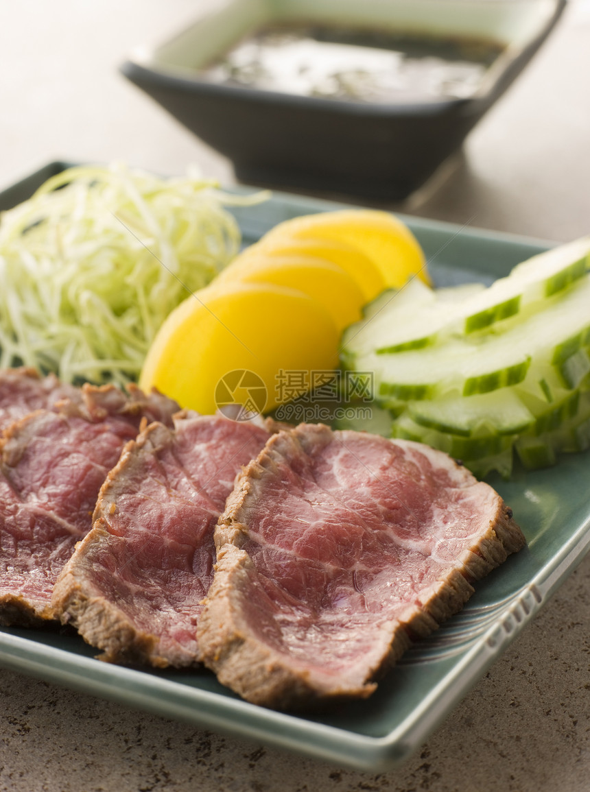 配有Ponzo酱的密封牛肉排酱油生产盘子蔬菜食物美食黄瓜食品图片