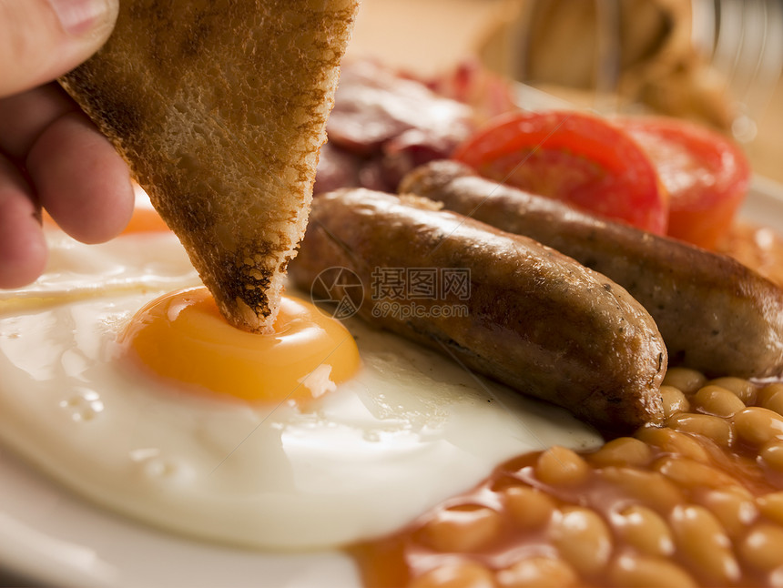将吐司加到炸鸡蛋上吃全英早餐烹饪中年食物男人男性香肠奶制品熏肉盘子双手图片