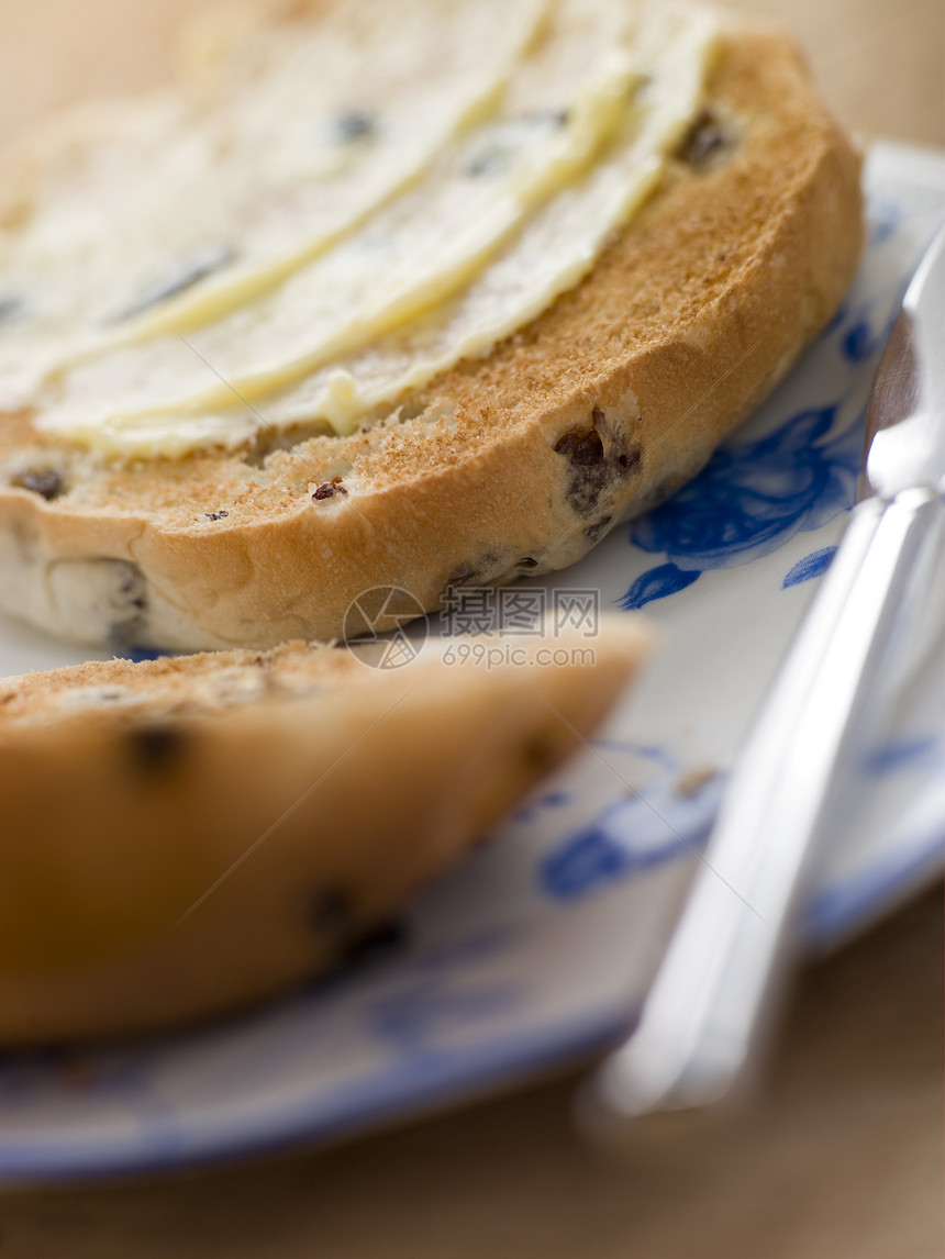 含黄油的烤茶蛋糕奶制品葡萄干甜食蜜饯面包用具甜点食物刀具厨房图片