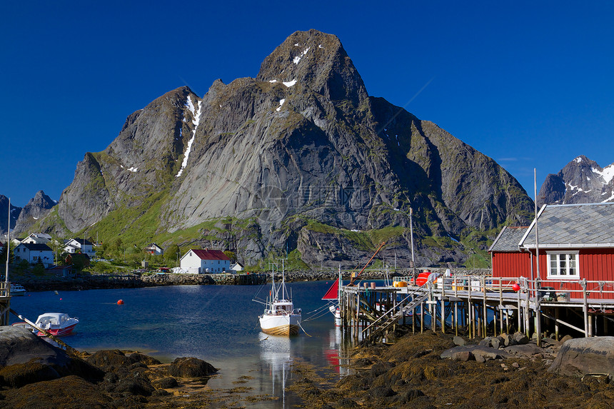 挪威渔村胜地小屋渔船房子钓鱼旅游山峰山脉红色大豆图片