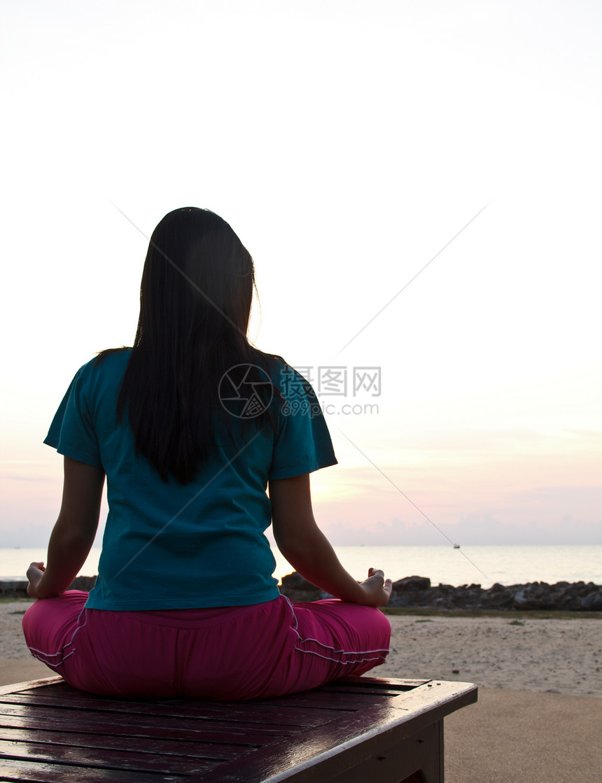 日落时在海滩冥想的女人活力女孩头脑衣服漂浮沉思海洋瑜伽反射身体图片