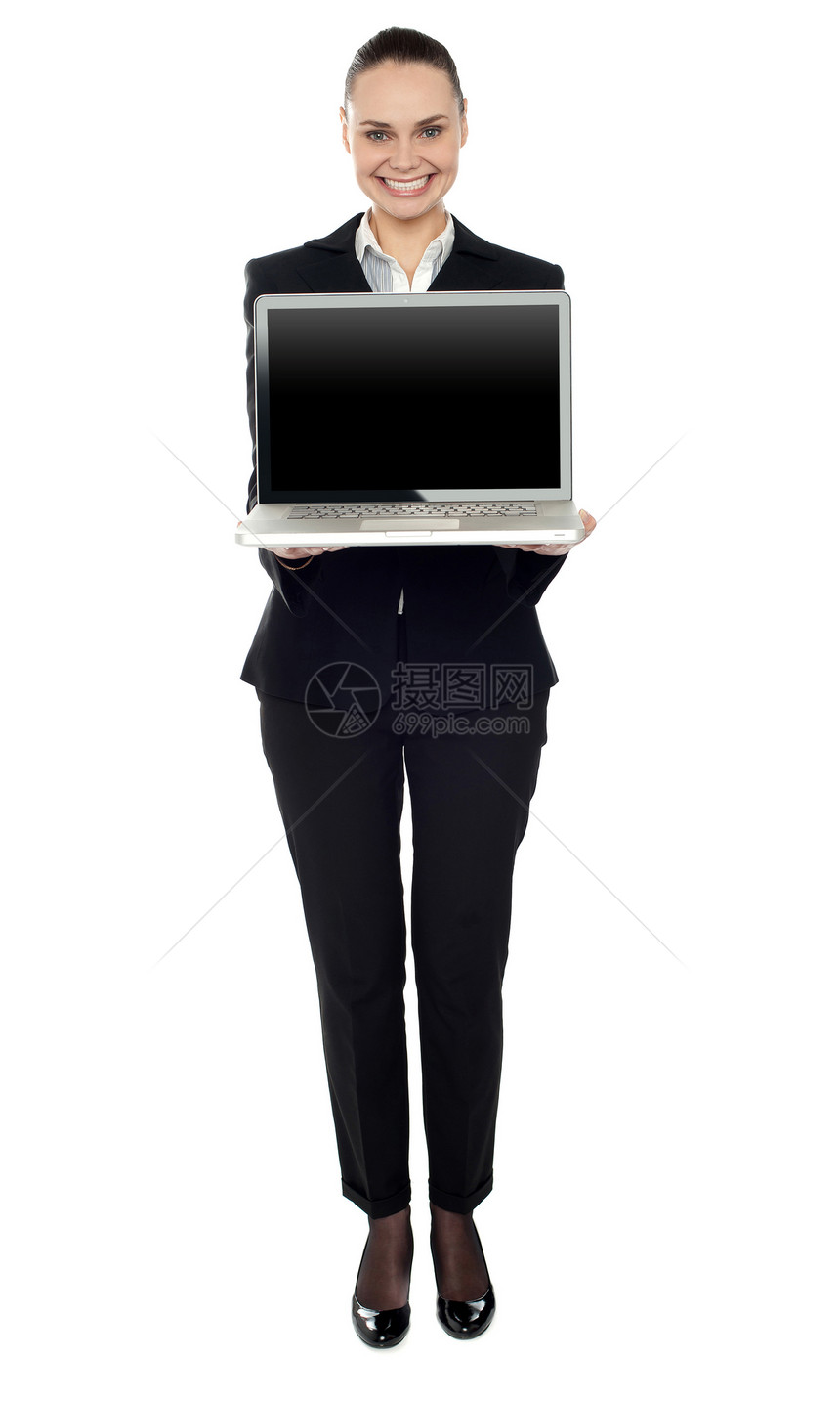 展示新笔记本电脑的妇女全长肖像图片