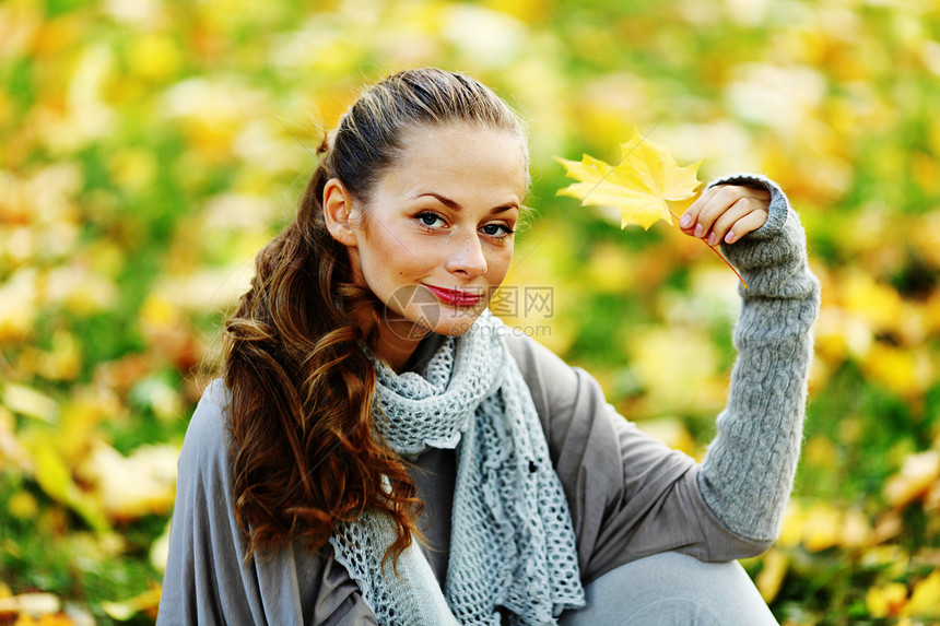 秋叶中的妇女脚尖眼睛微笑毛衣金发女郎橙子女性头发乐趣季节成人图片