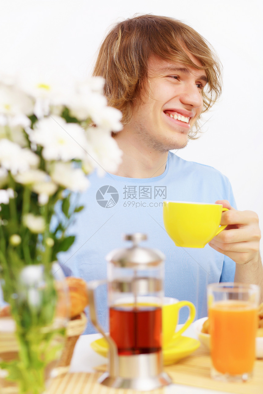 快乐的年轻人喝茶蓝色饮料闲暇幸福生活乐趣成人男性厨房杯子图片