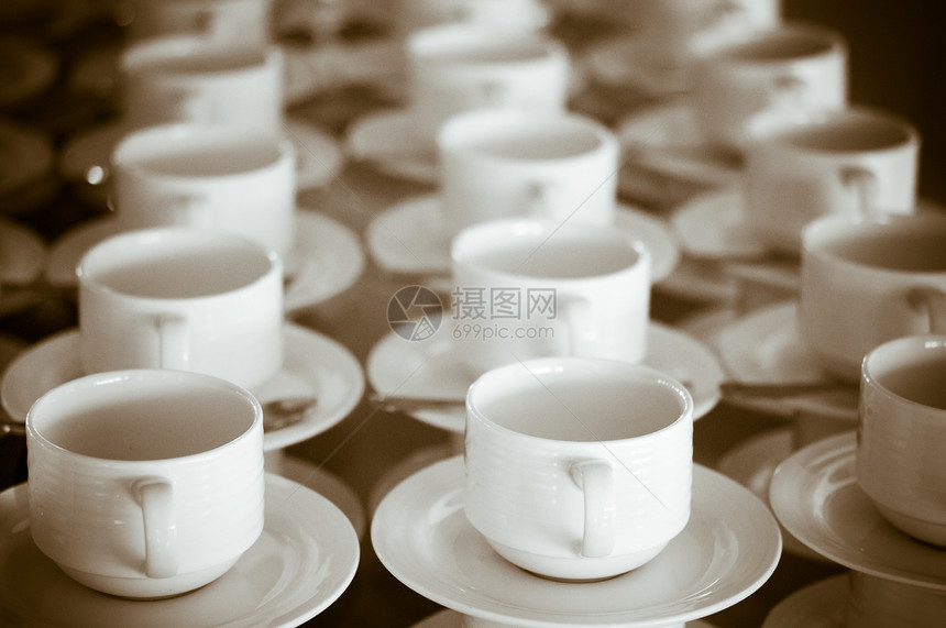 许多排长白杯和变换式的酱汁咖啡杯子团体饮料粮食飞碟餐厅桌子餐具服务图片