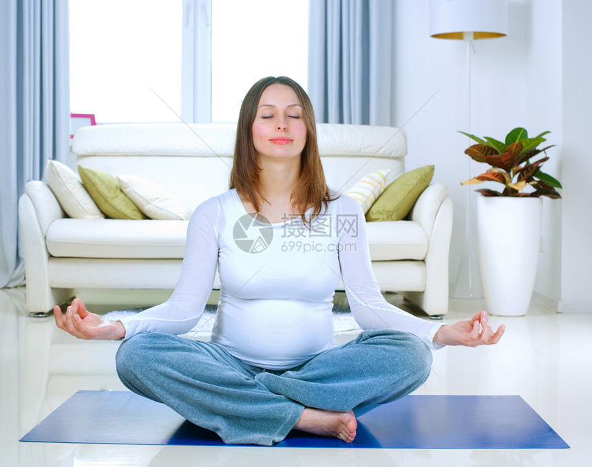 在家做瑜伽的美丽的孕妇妇女图片