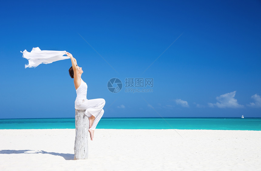 在海滩上快乐的女人海洋天堂乐趣晴天蓝色假期天空热带海岸自由图片