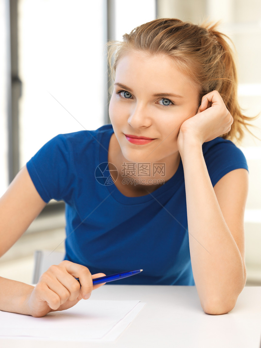 带着笔纸的快乐少女记录学校家庭笔记工作写作女性享受文档文书图片