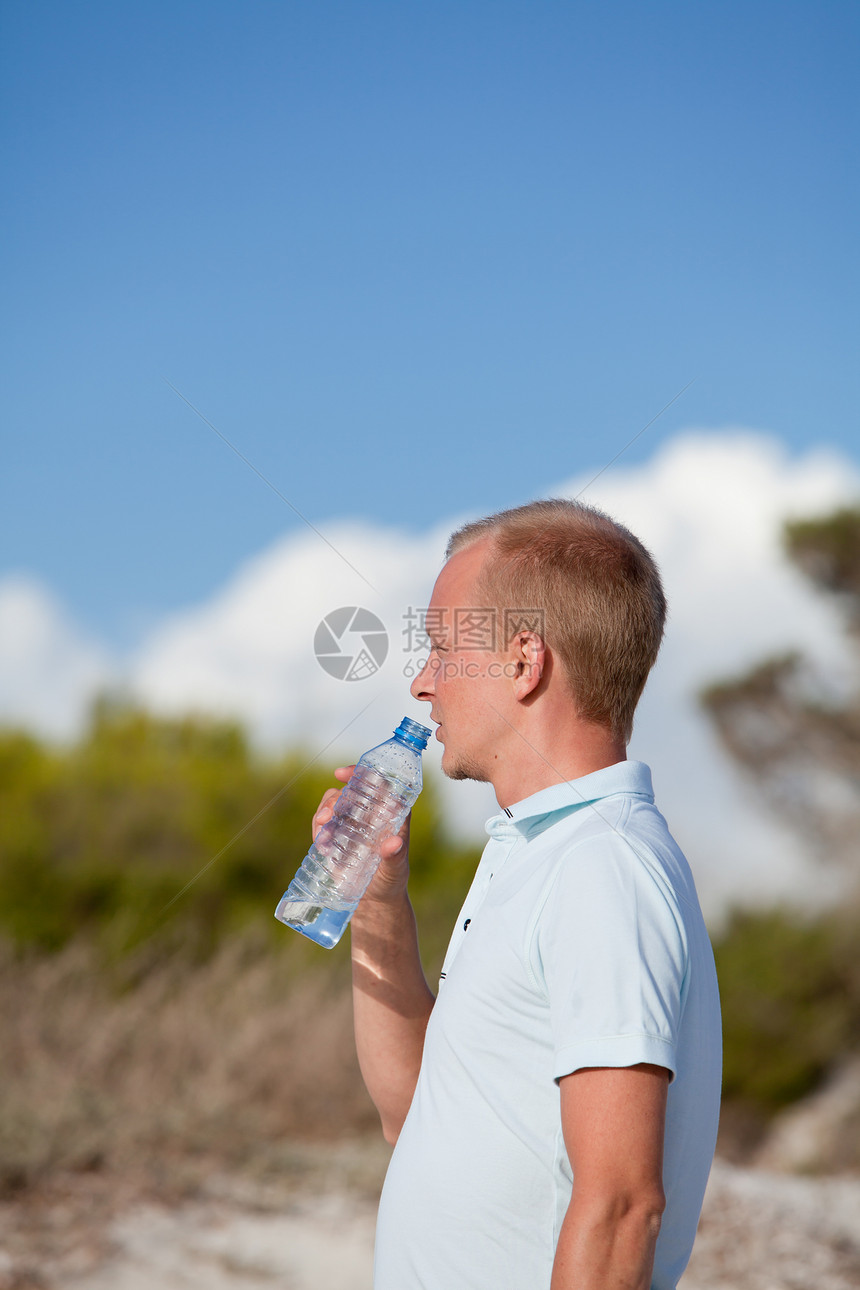 青年男子饮水夏日沙丘海滩天空液体成人海洋饮料沙丘海滩力量蓝色微笑假期图片