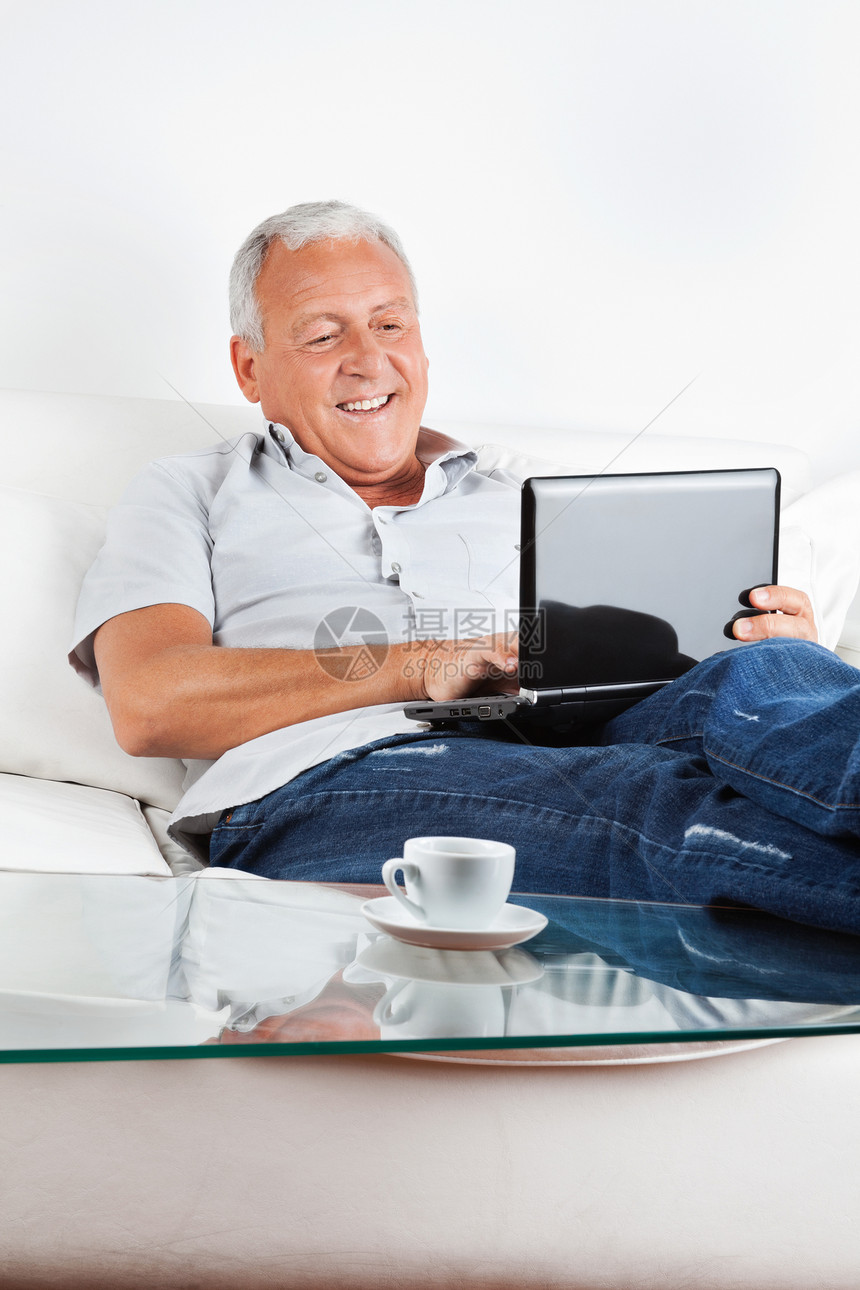 在笔记本电脑上工作成人公民男人房间养老金闲暇技术杯子幸福男性图片