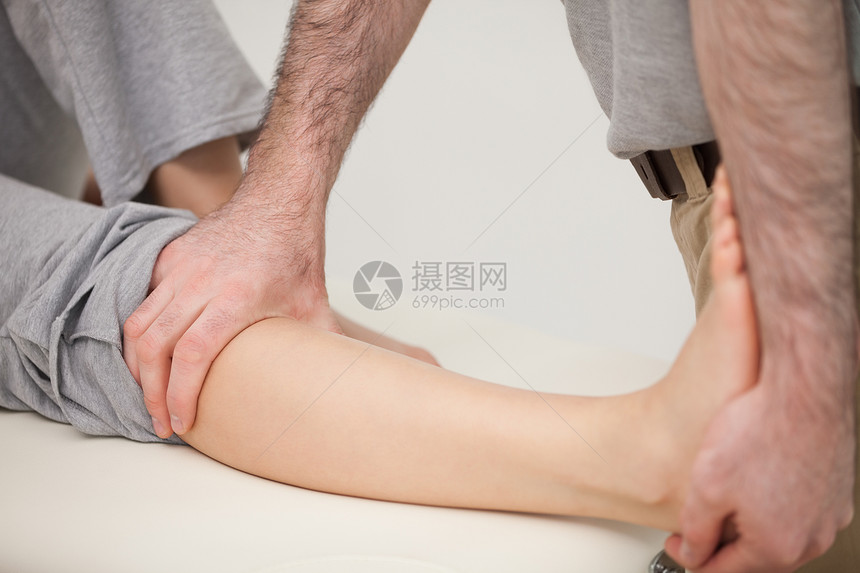 治疗师伸展病人的腿部图片