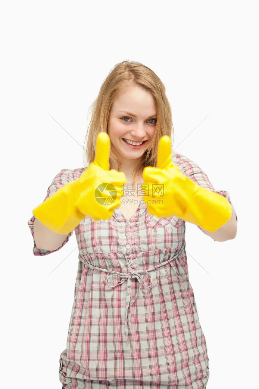 年轻女性在大拇指举起时佩戴清洁手套图片