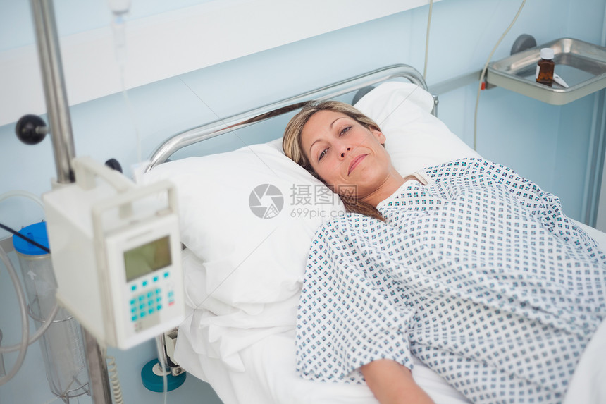 女病人在看照相机时躺在床上图片