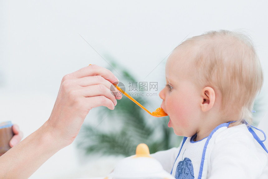 婴儿饮食食椅女性金发女郎蔬菜开幕式勺子女孩团结童年感情图片