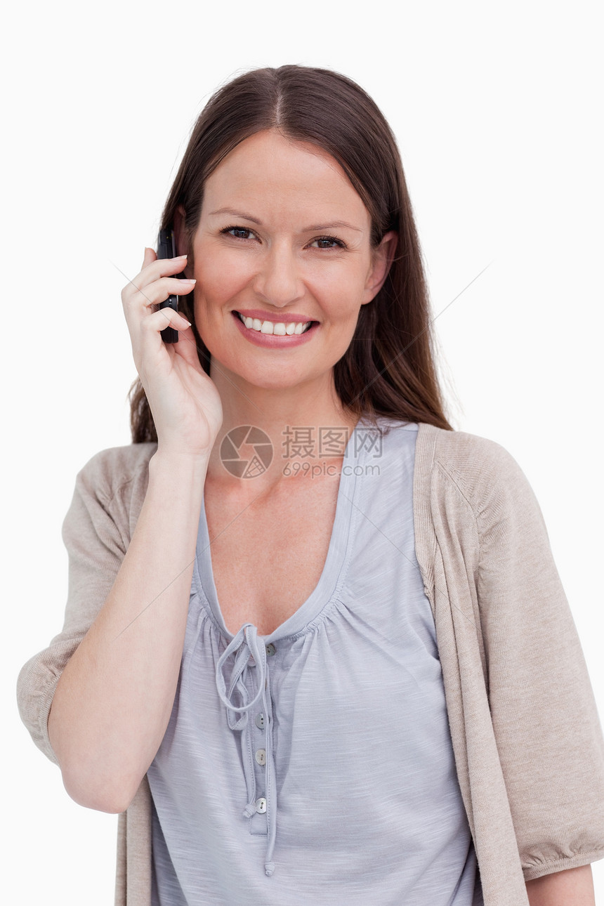 在手机上微笑的年轻女人 紧贴着她的笑容图片