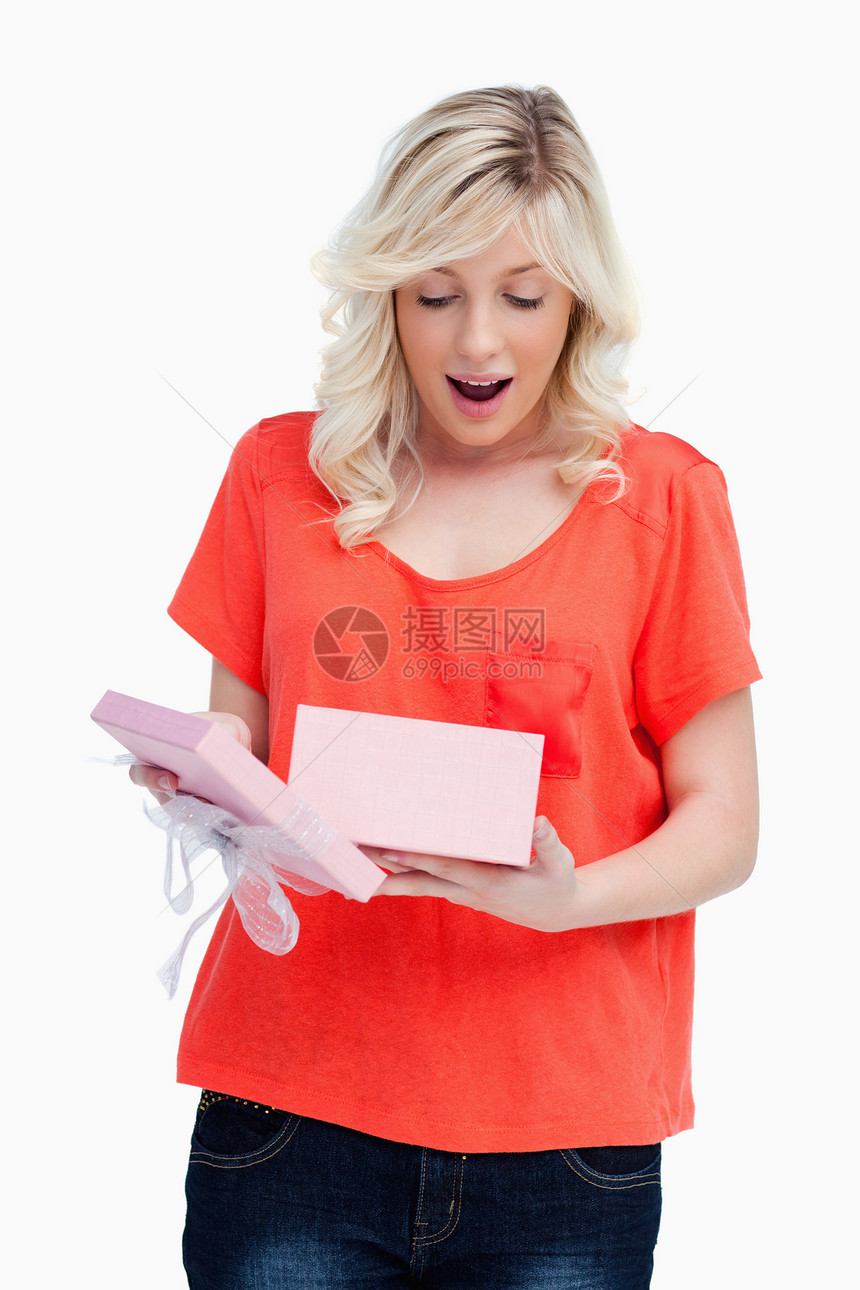 年轻金发女金发美女在开礼物时 展示出她的惊喜图片