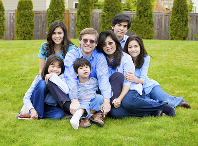 七个人7个大家族的7个大家庭坐在草坪上坐在一起 穿着蓝色衣服背景