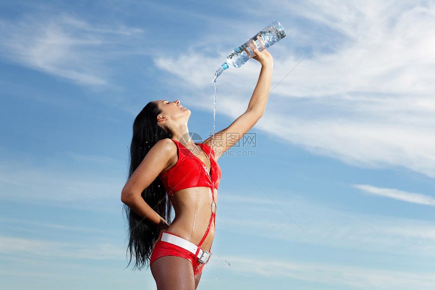 年轻女运动女青年 喝一瓶水黑发赛跑者毛巾锻炼矿物头发成人女性瓶子蓝色图片