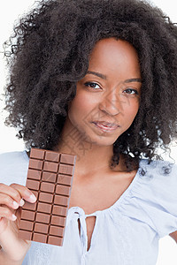 年轻女人拿着美味巧克力棒的巧克力背景图片