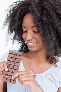年轻女人在看一个美味的巧克力吧背景图片