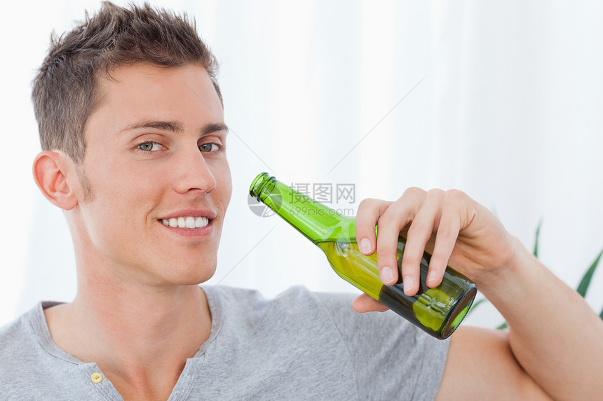 一个笑着喝啤酒的男人 嘴边有啤酒图片