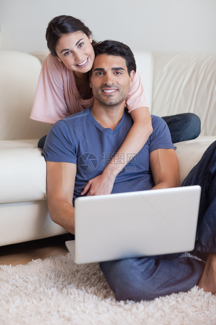 用笔记本电脑画一对可爱夫妇的肖像闲暇喜悦客厅幸福技术微笑沟通电子邮件上网互联网图片