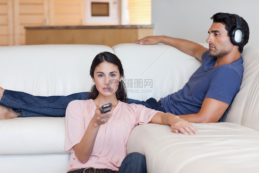 女人在看电视 而她的男朋友却在听穆歌图片