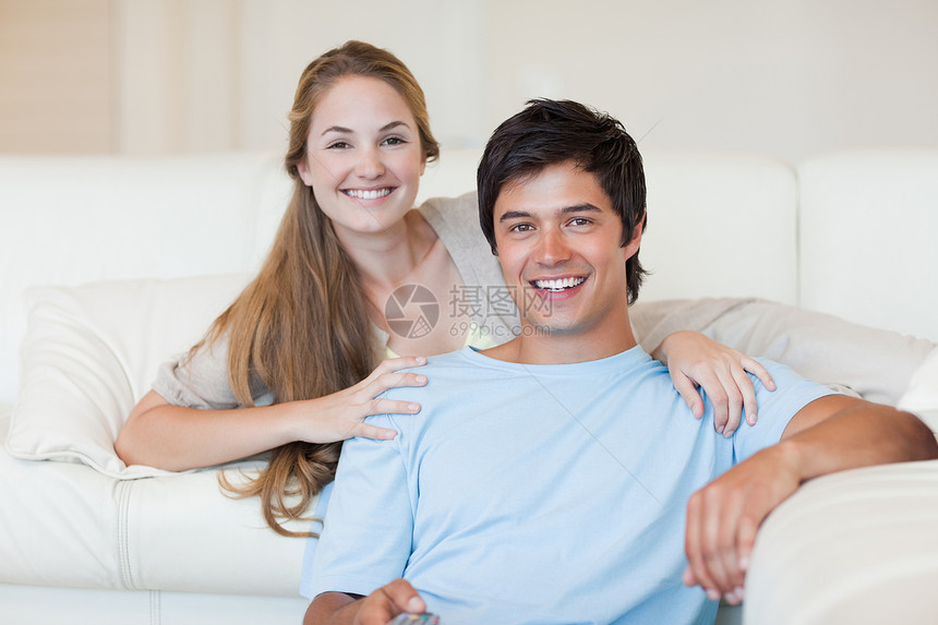在看电视的一对微笑的夫妇图片