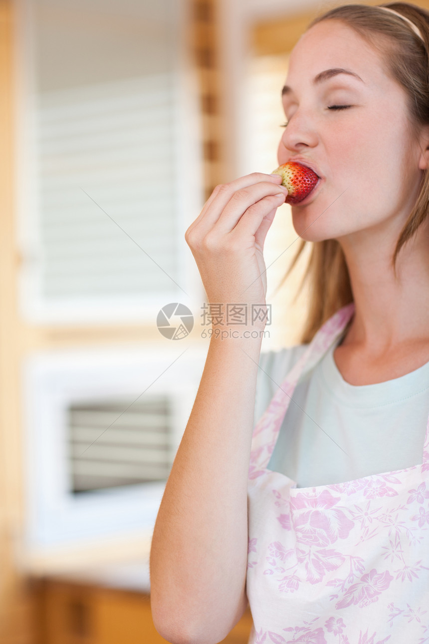 一个女人吃草莓的肖像乐趣幸福营养小吃浆果重量食物活力饮食水果图片
