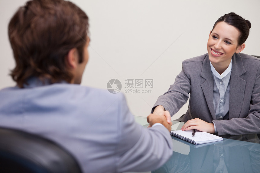 女商务人士欢迎顾客到她的办公室来就业职业谈判申请人沟通外表讨论女性桌子协议图片