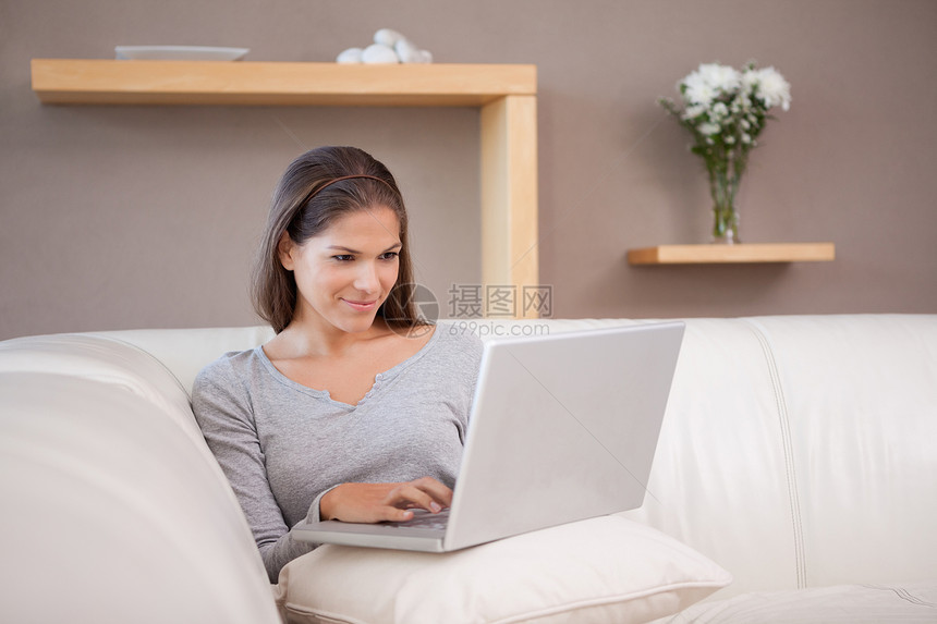 沙发上有笔记本的女人客厅闲暇喜悦女性电脑享受沟通网络冲浪外表图片