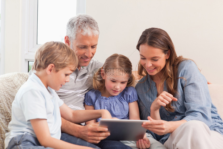 幸福家庭使用平板电脑儿子女儿丈夫母亲爱好微笑控制互联网团结女孩们图片