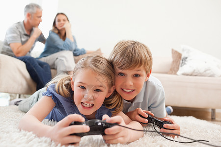 与父母玩电子游戏的孩子们都开心起来了高清图片
